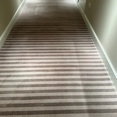 a hallway with striped carpet and white walls