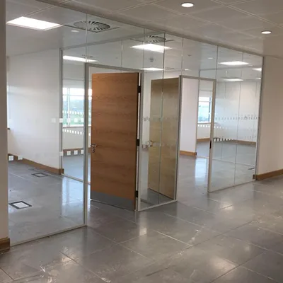 an empty room with glass walls and a wooden door