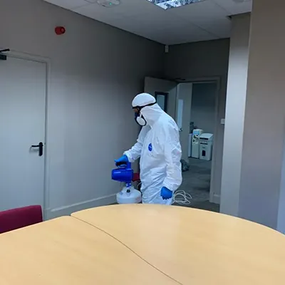 a man in a protective suit spray painting a room